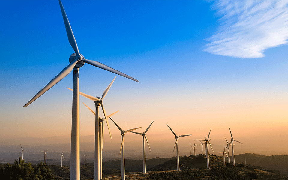 A group of six windmills in a field.
